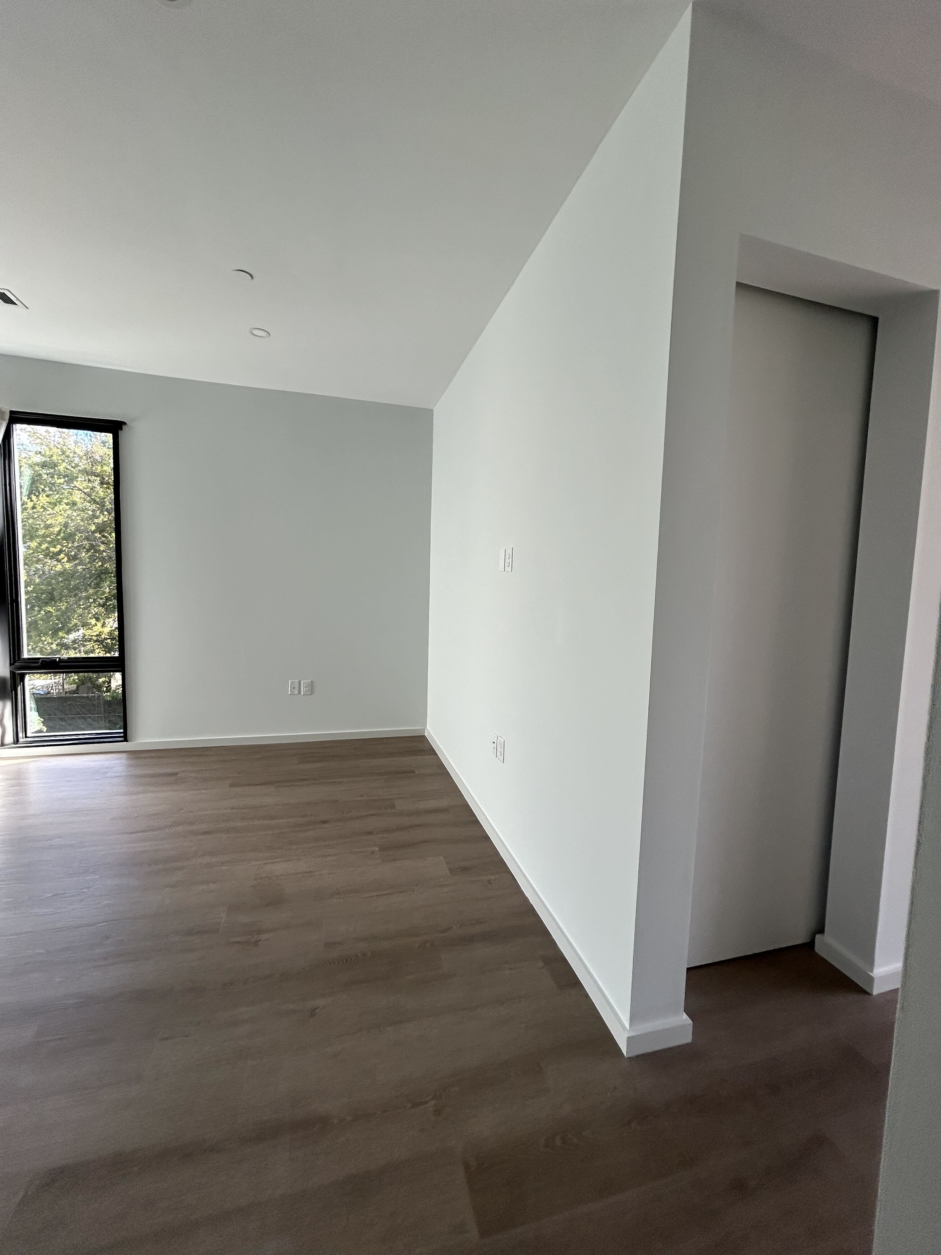Bright freshly painted bedroom with clean white walls and a vaulted ceiling