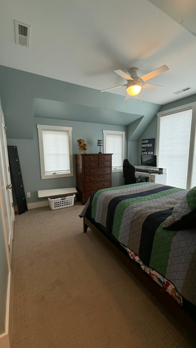Bedroom with seafoam green accent wall and crisp white trim after repaint